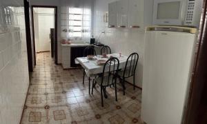 a kitchen with a table and chairs and a refrigerator at Apartamento Centro SerraNegra in Serra Negra