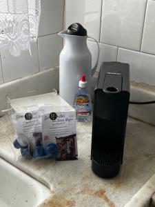 a kitchen counter with a hair dryer and a bottle of milk at Apartamento Centro SerraNegra in Serra Negra