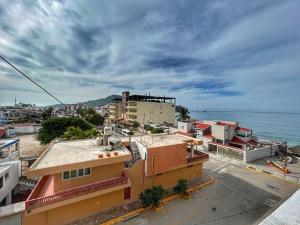 a group of buildings with the ocean in the background at Apartment 3 Maleconcito del Sol Barra de Navidad in Barra de Navidad