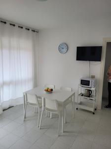a white dining room with a white table and chairs at Casa Orchidea in Castelsardo