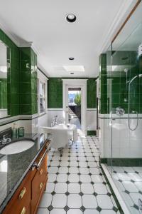 ein Badezimmer mit grünen Wänden, einer Badewanne und einem Waschbecken in der Unterkunft The Vancouver Heritage Home - Mount Pleasant in Vancouver