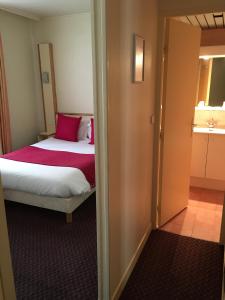 a bedroom with a bed with a pink pillow at Hotel Antin St Georges in Paris +16 photos
