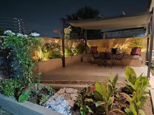 a patio at night with a table and chairs at Oheneba Tema - Luxury Hot -Tub Retreat with Wi-Fi in Tema