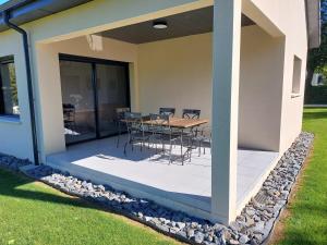 Senneville-sur-FécampにあるGite au coeur de Sennevilleの家の上にテーブルと椅子付きのデッキ +7枚の写真