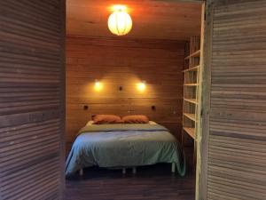 a bedroom with a bed in a wooden cabin at Le triskel de Bertaud in Bain-de-Bretagne