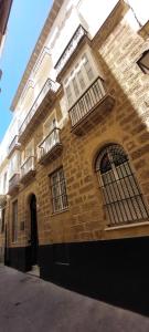 a brick building with windows and balconies on it at el 2 de Flamenco 2ºA in Cádiz