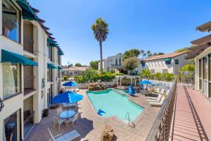 アロヨ・グランデにあるBest Western Casa Grande Innの建物の隣にスイミングプール(椅子、パラソル付)
