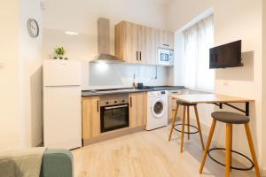 een keuken met een witte koelkast en een tafel bij Málaga Center Home in Málaga