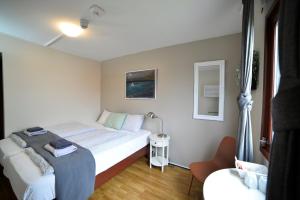a small bedroom with a bed and a chair at Klausturhof Guesthouse in Kirkjubæjarklaustur +63 photos
