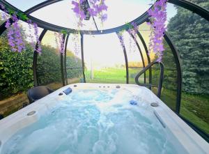 a hot tub in a garden with purple flowers at B&B Margot in Albavilla