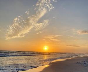 a sunset on the beach with the sun setting at Three Pools, Steps to Beach, Dining and Shopping! in Santa Rosa Beach