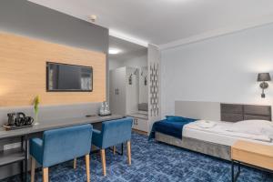 a bedroom with a bed and a desk and a tv at Hotel w Dobieszkowie in Stryków +113 photos