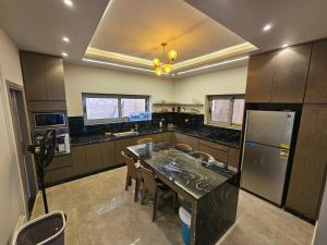 a large kitchen with a table and a refrigerator at Happy Villa For Families Only in Alexandria