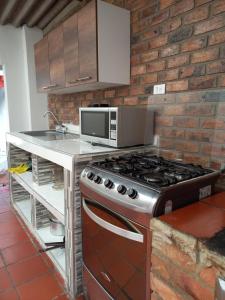 a kitchen with a stove and a microwave at MariaAuxiliadora in Monguí +34 photos