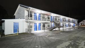 a large white building with blue doors at night at Royal Inn Cochran in Cochran