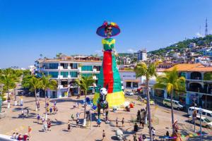 Una gran estatua de una mujer en un sombrero en una calle de la ciudad en Casa ArtWalk, en Puerto Vallarta
