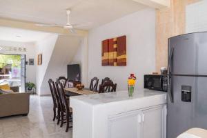 Una cocina y una sala de estar con refrigerador y una mesa. en Casa ArtWalk, en Puerto Vallarta