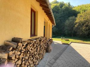 a pile of logs sitting next to a building at Villa Negra Vendégház in Parádsasvár