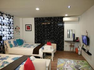 a hotel room with two beds and a living room at Jia Mei Fa Homestay in Taitung City