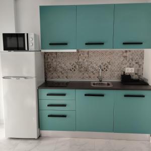 a kitchen with blue cabinets and a white refrigerator at Apartamento SUN GATE in Jerez de la Frontera