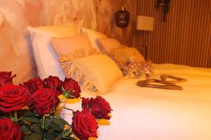 a white bed with red roses and a bunch at Love room la bohème in Baccarat