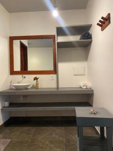a bathroom with a sink and a mirror at Casa Praiana Moitas in Praia de Moitas