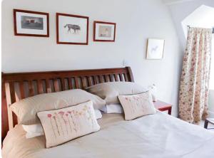 Un dormitorio con una cama blanca con dos almohadas. en Tor Royal Farm House, en Princetown 13 fotos más