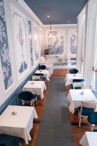 a restaurant with white tables and blue and white walls at Parc Royal Suites Hotel in Cuenca +107 photos