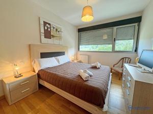 a bedroom with a bed with two stuffed animals on it at Casa Olmo apartamento en LLanes in Llanes