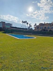 an empty swimming pool in a field of grass at Casa Olmo apartamento en LLanes in Llanes