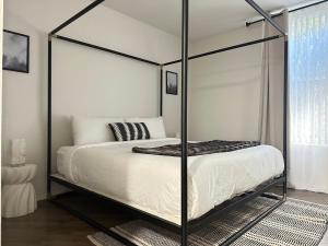 a bedroom with a canopy bed with white sheets at Beautiful Getaway Near Venice in Los Angeles