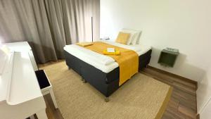 a bedroom with a bed with a yellow blanket on it at City Luppo - Spacious, Smart, Warm, Sauna, Wi-Fi in Rovaniemi
