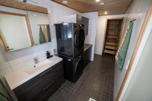 a small bathroom with a sink and a refrigerator at City Luppo - Spacious, Smart, Warm, Sauna, Wi-Fi in Rovaniemi +46 photos