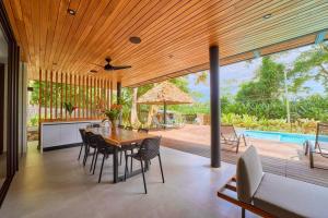 a dining room with a table and chairs and a pool at Casa Diwo in Puerto Viejo