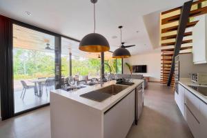a kitchen with white counters and a large window at Casa Diwo in Puerto Viejo
