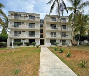 La LomaにあるApartamento en puerta del solのヤシの木が前に生えている大きな建物