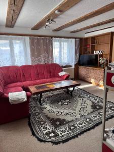 a living room with a red couch and a coffee table at Familie Zimmer in Ramsen