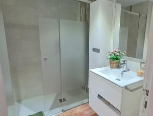 un bagno bianco con lavandino e doccia di Marineda Sol a El Médano Altre 13 foto