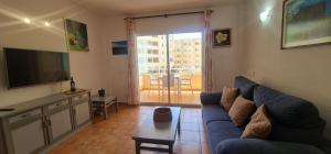 un soggiorno con un divano blu e una televisione di Marineda Sol a El Médano