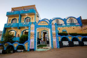 a blue and yellow house with a blue and white facade at Fadlos Anay Nubian Guesthouse فضلوس أناي in Aswan
