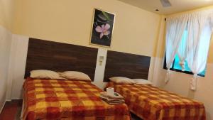 a bedroom with two beds and a window at Casa O K in Tecolutla