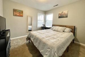 a bedroom with a bed and a television in it at Homestead Haven in Concord
