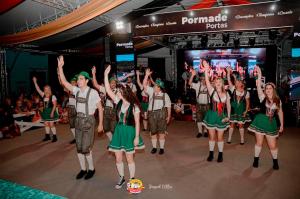 a group of girls dancing on a stage with their hands in the air at Opera Hotel in Pôrto União