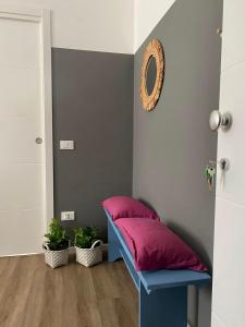 a blue bench with a pink cushion in a room at Soria Home-A due passi da Centro e Mare in Pesaro