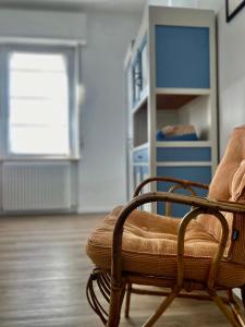 a living room with a chair and a book shelf at Soria Home-A due passi da Centro e Mare in Pesaro