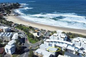 una vista aerea di una spiaggia con edifici e l'oceano di Kings Beachfront Haven at Seamist a Caloundra