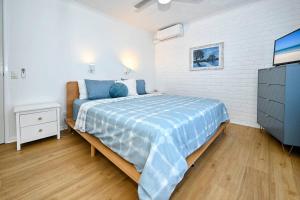 una camera da letto con un letto e una TV di Kings Beachfront Haven at Seamist a Caloundra