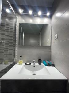 a bathroom with a white sink and a mirror at Piso con Vistas y Mucho Encanto in Madrid +18 photos