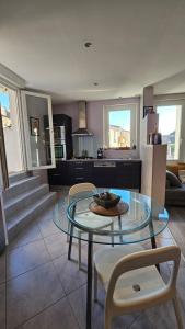 a living room with a glass table and chairs at Appartement PETIT SAINT GIMER in Carcassonne