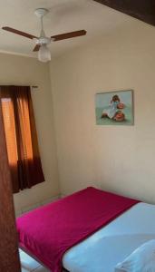 Un dormitorio con una cama con ventilador de techo. en Hotel Thalita, en Formiga